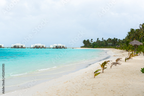 Fototapeta Naklejka Na Ścianę i Meble -  tropical beach with palm trees, white sand and turquoise blue water and water bungallows