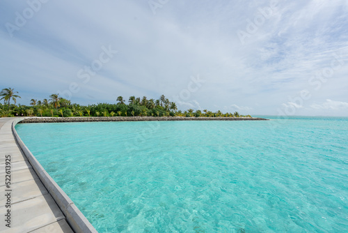 Maldives resort bridge in tropical bay, exotic paradise with turquoise water and palm trees