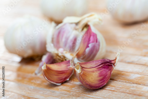 Fototapeta Garlic cloves and bulb on the cutting board closeup