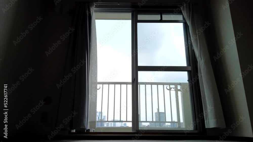 A skyscraper seen from the window of vacant studio apartment and curtains swaying in the wind. timelapse. A skyscraper seen from the window of vacant studio apartment and curtains swaying in the wind. timelapse.