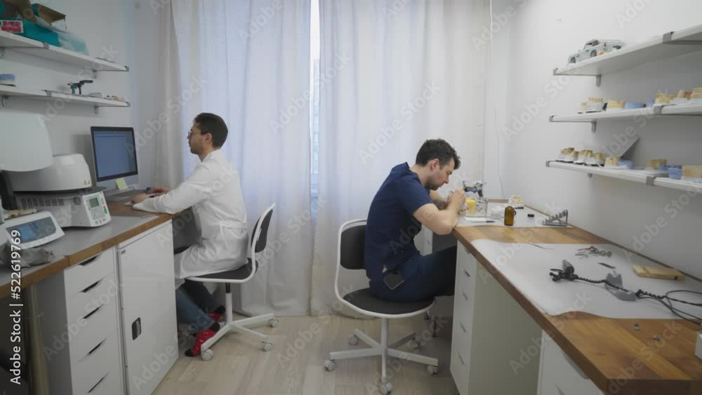 Doctors Prepare Materials For Dental Treatments In Clinic Laboratory. Doctor Works With Computer To Plan Dental Care For Clinic Patients. Doctor Manually Manufacturing Dental Crowns. Dentistry Clinic Doctors Prepare Materials For Dental Treatments In Clinic Laboratory. Doctor Works With Computer To Plan Dental Care For Clinic Patients. Doctor Manually Manufacturing Dental Crowns. Dentistry Clinic
