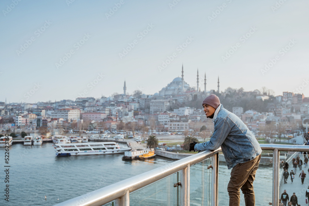 Fototapeta premium man standing on the bridge while enjoying the view of bosphorus istanbul turkey