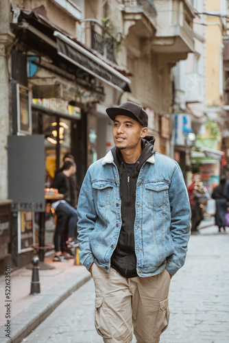 portrait of young male with denim jacket walking on historical city of istanbul