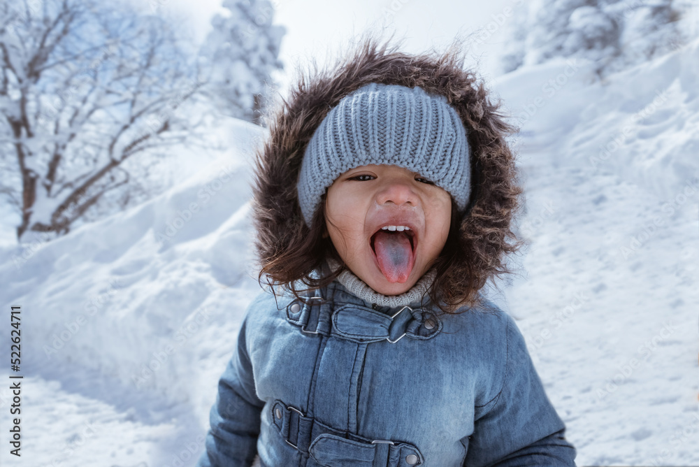 cute kid portrait close up while enjoying lollipop outside during snowy winter cute kid portrait close up while enjoying lollipop outside during snowy winter