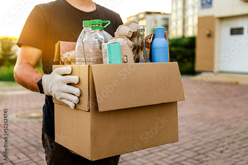 a man carries garbage in a box for sorting. The concept of caring for the environment and ecology © ProstoSvet