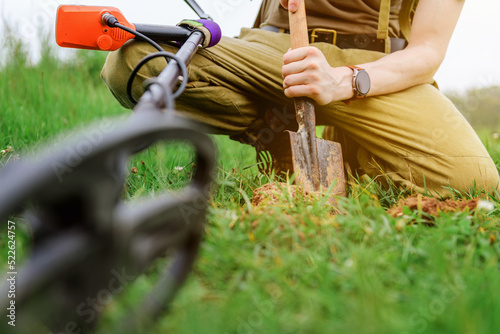 metal detector at work in the forest or field. Search for treasure and ancient values. Archeology. Man with a metal detector. Military sapper photo