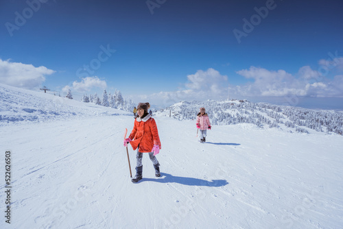 two girl playing with snow. asian little sister enjoy their time in snowy winter together