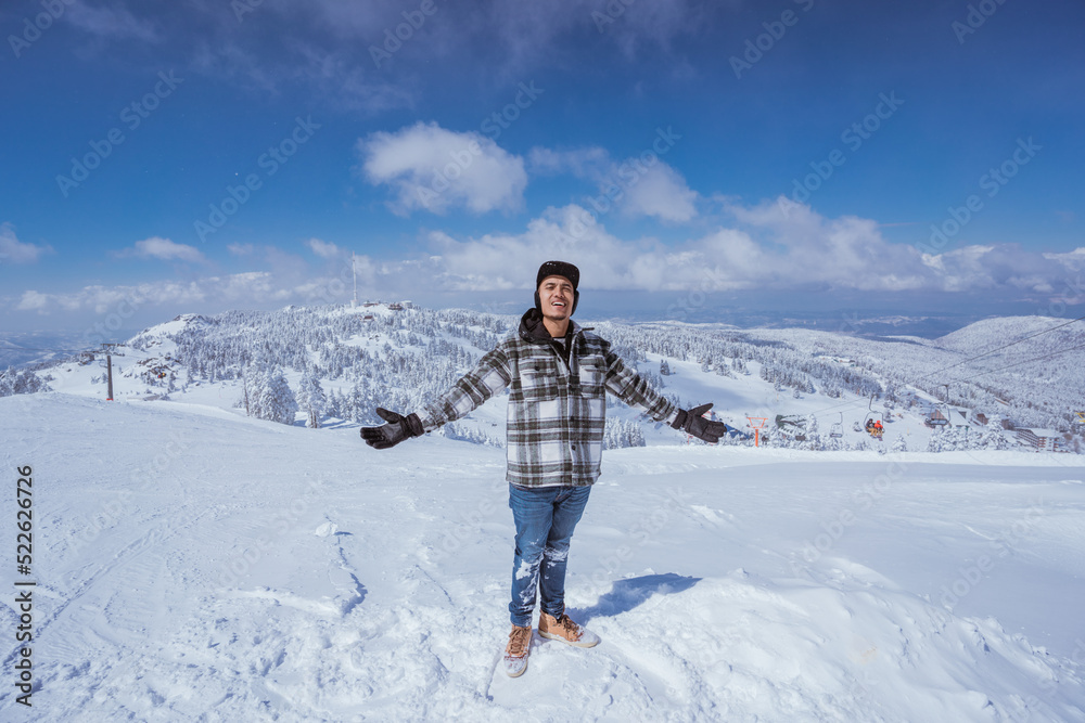 portrait of young man looking at camera while standing at the top of snowy mountain portrait of young man looking at camera while standing at the top of snowy mountain