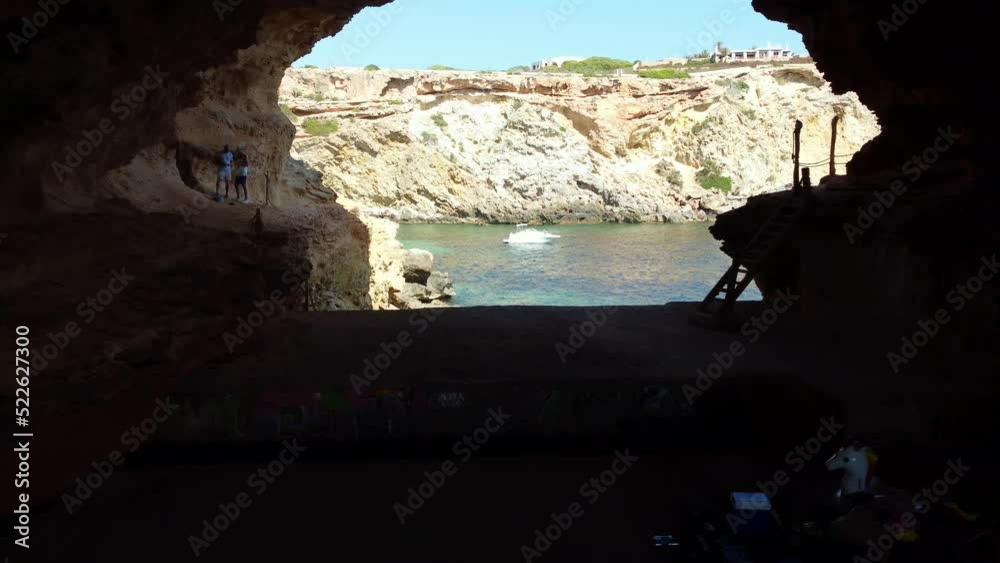 Out of cave to boat and luxury villa
Unbelievable aerial view flight fly forward drone footage
of cliff edge beach Sa Figuera borda Ibiza summer 2022. 4k Cinematic from above by Philipp Marnitz