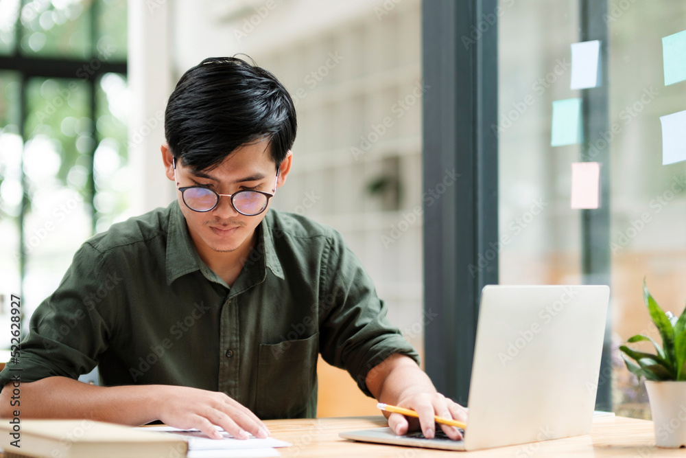 Young asian business man or student working online on computer laptop.