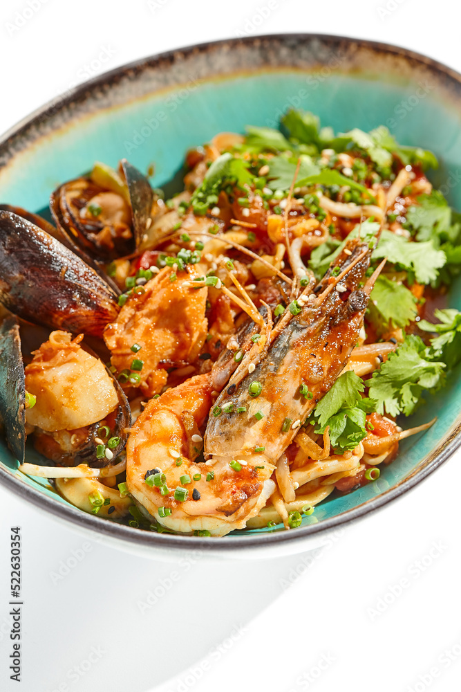 Japanese soba with seafood cooked on wok in asian style on white background. Noodle seafood in ceramic bowl. Indonesian wok with prawn, mussels and soba noodles. Spicy thai dish with shrimp and udon. Japanese soba with seafood cooked on wok in asian style on white background. Noodle seafood in ceramic bowl. Indonesian wok with prawn, mussels and soba noodles. Spicy thai dish with shrimp and udon.