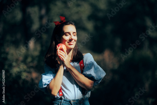 Beautiful Modern Snow-White Princess Holding an Apple in the Woods. Cool trendy fairytale character having a fashionable costume 