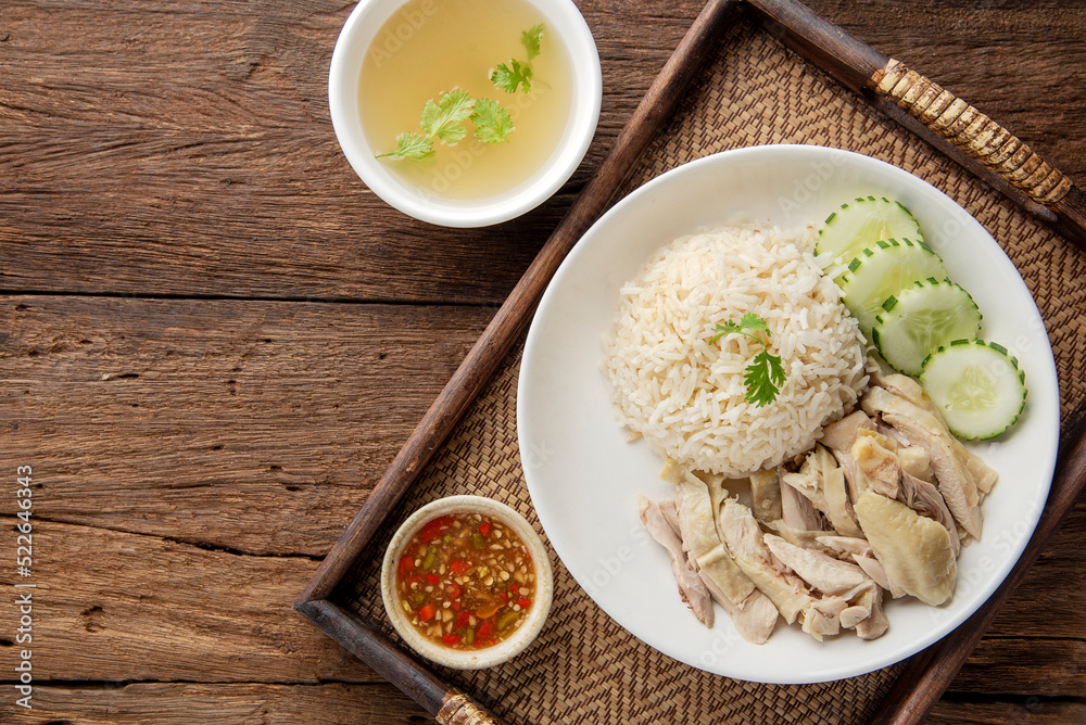 Hainanese chicken rice with soup on dark wooden table background. thaifood concept.