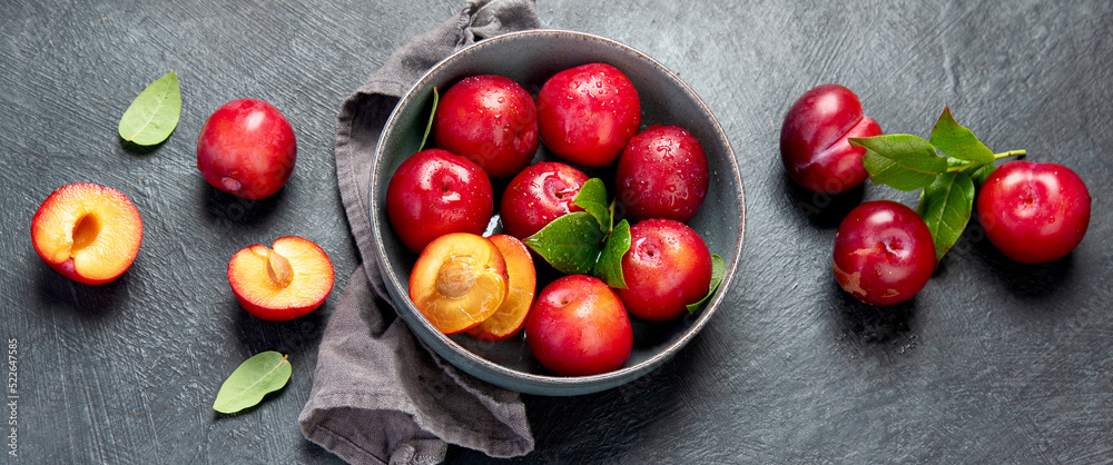 Fresh red plums in plate. - obrazy, fototapety, plakaty 