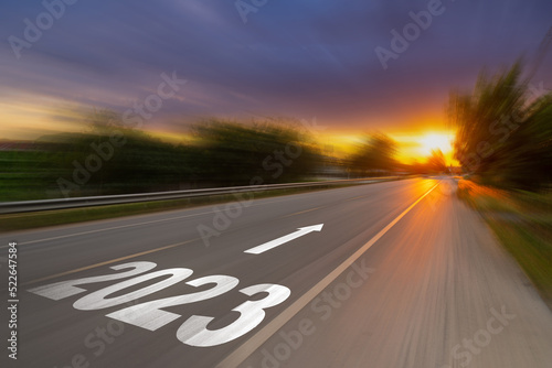 Motion blur empty asphalt road and New year 2023 concept. Driving on an empty road to Goals 2023 with sunset.