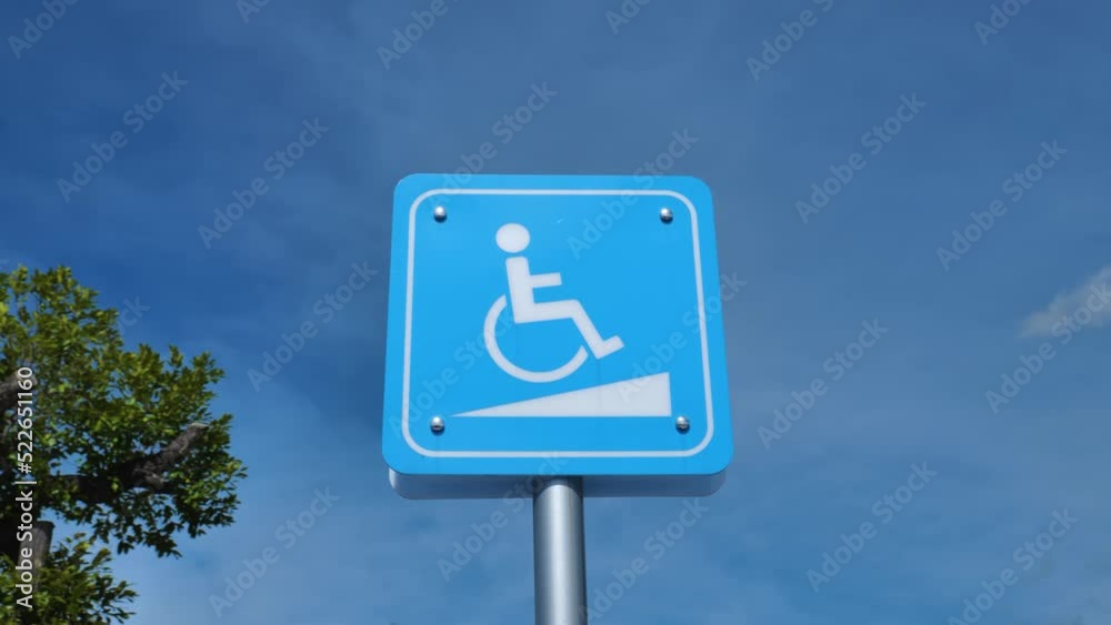 The handicap sign is outside the building. The handicap sign is outside the building.
