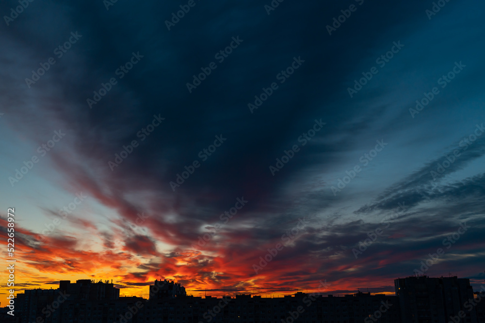 dawn over a modern city with red clouds