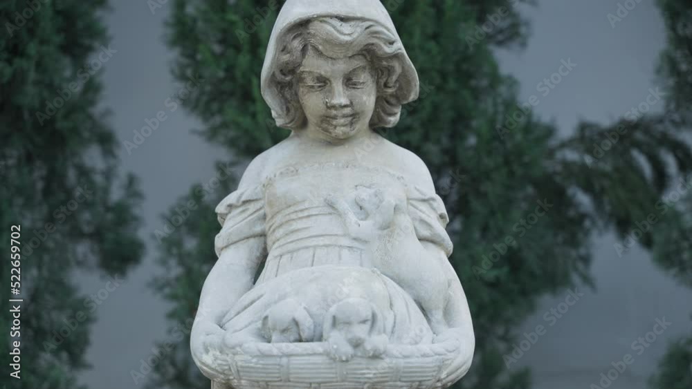 Statue of a girl holding dogs in a basket Statue of a girl holding dogs in a basket
