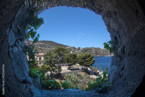 View from a ivy-covered castle window onto Lipari harbour and sea