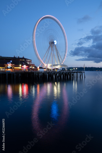 Ferris wheel reflecting in water at night