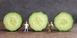 Three slices of cucumber and a miniature chef and a miniature farmer. Business concept with a slice of cucumber and miniature people.
