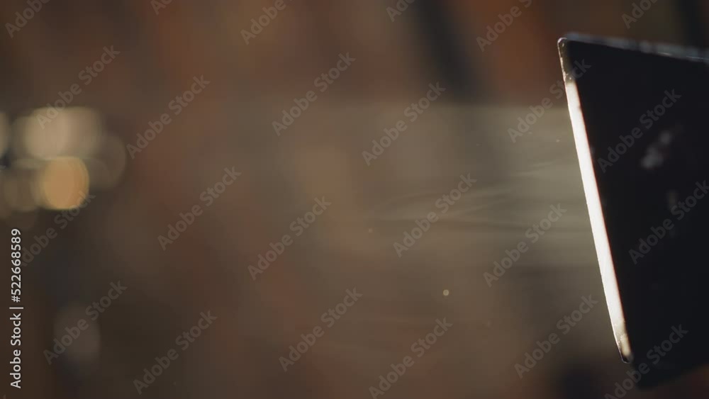 Gentle smoke flow swirls in light beam of glowing projection lamp on blurred background closeup. Mystical fog as stage decor. Technology and design Gentle smoke flow swirls in light beam of glowing projection lamp on blurred background closeup. Mystical fog as stage decor. Technology and design