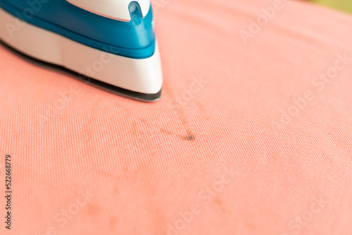 Close up of stain of dirt on clothes after ironing. Iron on cloth with spot of dirt