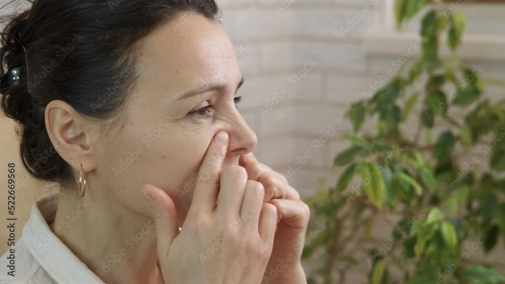 Nose drainage. A woman practice nose drainage self massage with fingers at home. A concept of self help during isolation. Nose drainage. A woman practice nose drainage self massage with fingers at home. A concept of self help during isolation.