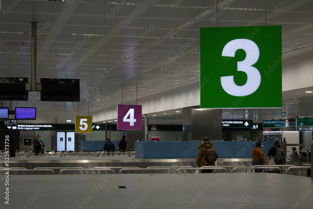 evocative image of a numerical series from 3 to 5 of baggage conveyor belts in an airport
