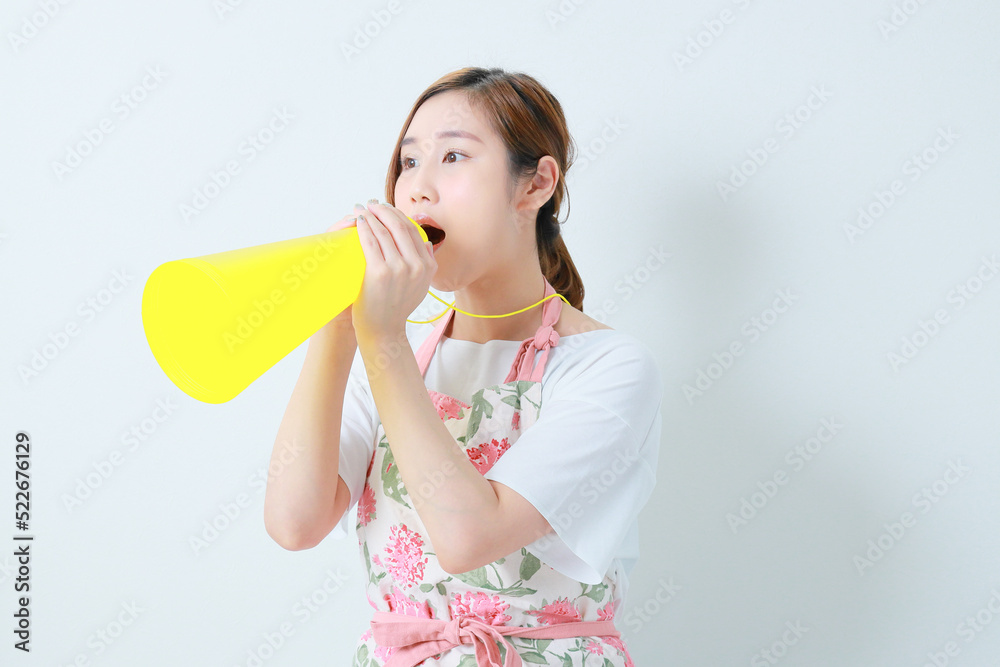黄色のメガホンを持って叫ぶ若い女性 黄色のメガホンを持って叫ぶ若い女性