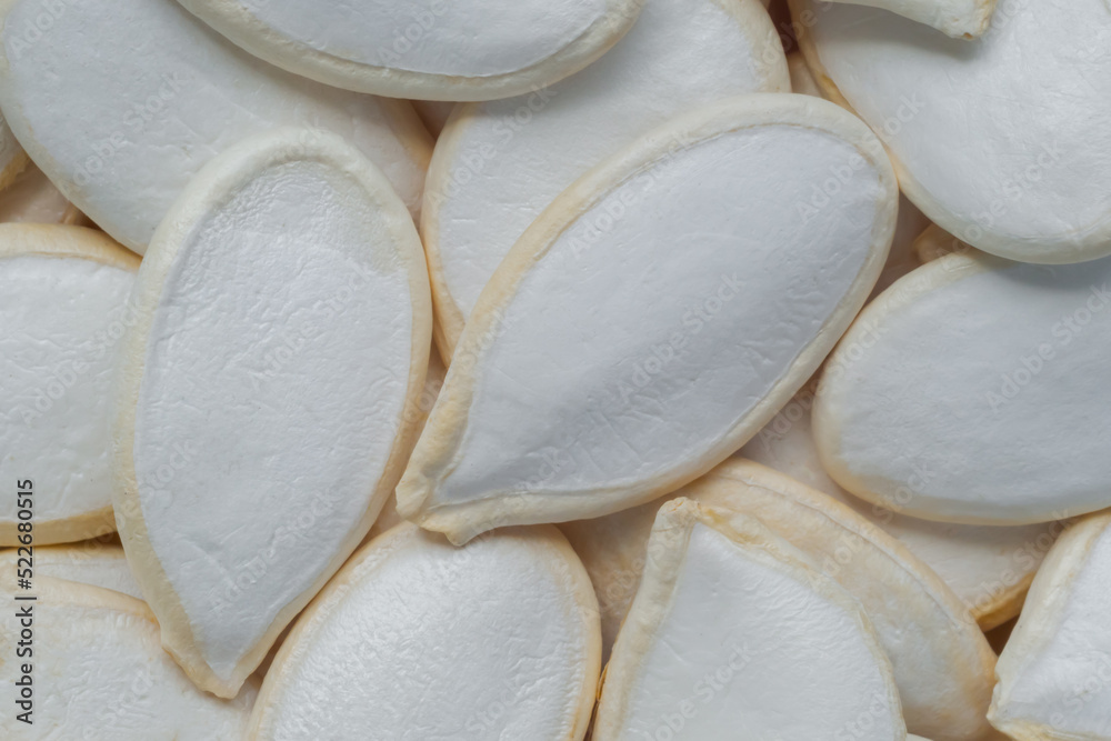 Heap of uncooked raw white pumpkin seeds - close up, macro, top view. Healthy food concept Heap of uncooked raw white pumpkin seeds - close up, macro, top view. Healthy food concept