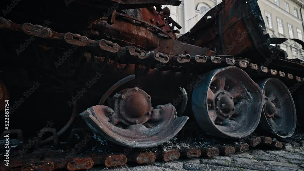Caterpillar and wheels track of burned-out Russian tank. Close up. soldier hand touches a tank track. Military battle army war concept Caterpillar and wheels track of burned-out Russian tank. Close up. soldier hand touches a tank track. Military battle army war concept