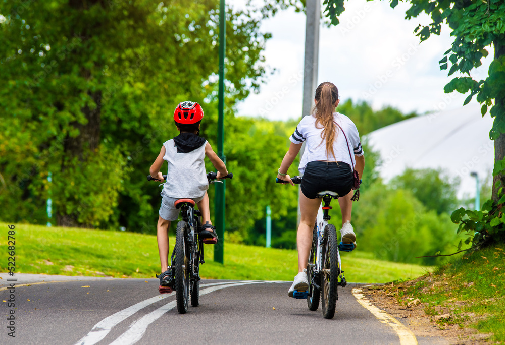 Fototapeta premium A boy and a girl ride bicycles in a city park