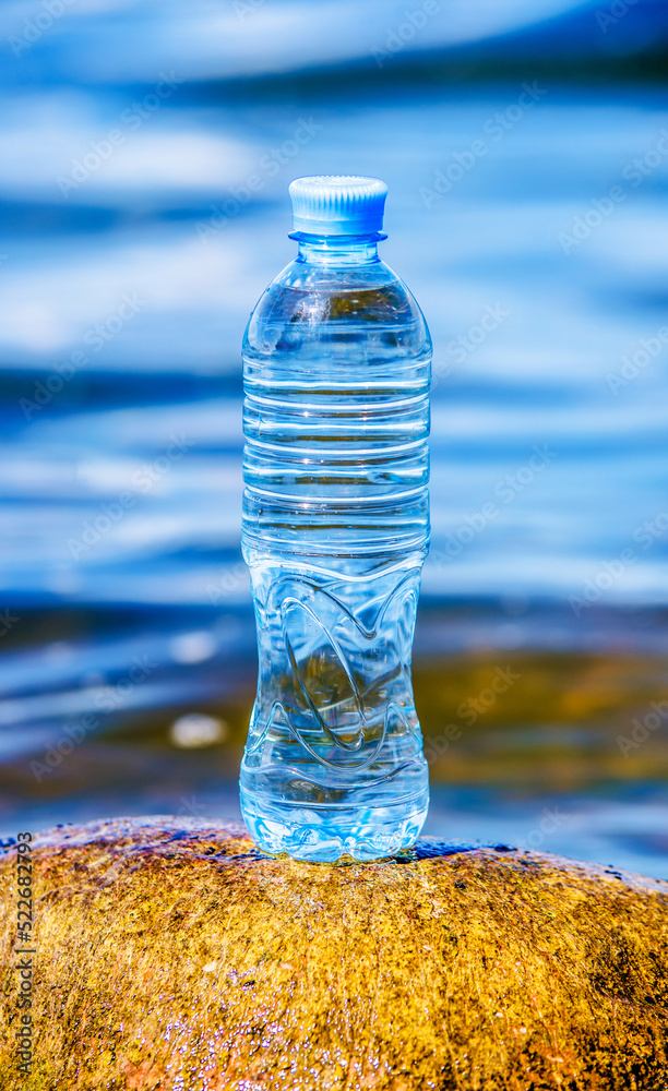 A bottle of drinking water stands on a stone on the seashore
A bottle of drinking water stands on a stone on the seashore