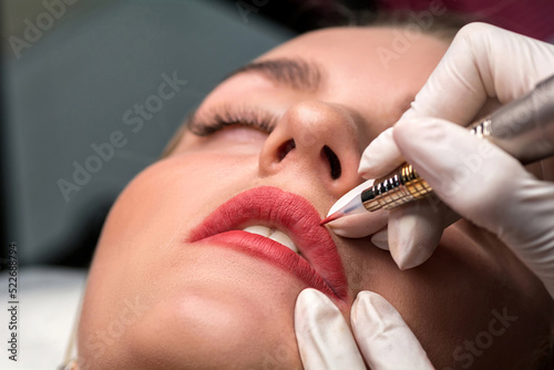 Permanent make up procedure. Lip makeup in tattoo salon.