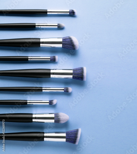 Creative concept beauty fashion photo of cosmetic product make up brushes kit on blue background.