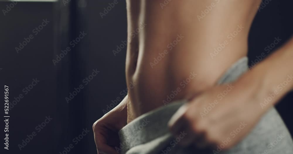 Fit, healthy and toned womans stomach muscles after training her ab exercises during her fitness workout routine in the gym. Athletic female shows her sexy, desirable and alluring body in a close up