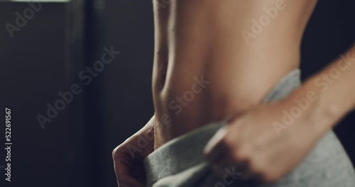 Fit, healthy and toned womans stomach muscles after training her ab exercises during her fitness workout routine in the gym. Athletic female shows her sexy, desirable and alluring body in a close up