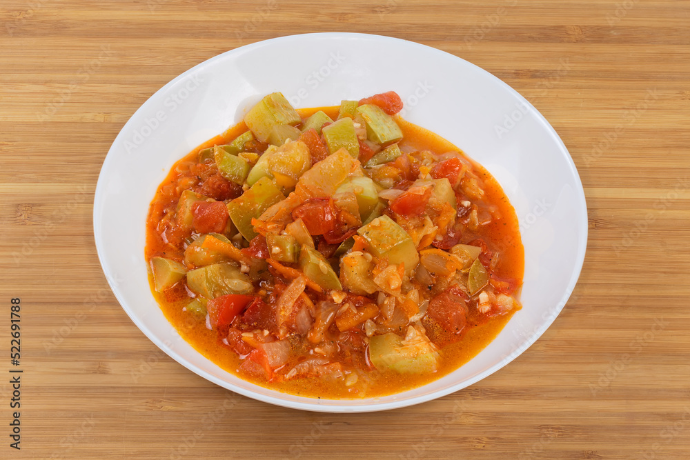 Marrows stewed with other vegetables in bowl on wooden surface Marrows stewed with other vegetables in bowl on wooden surface