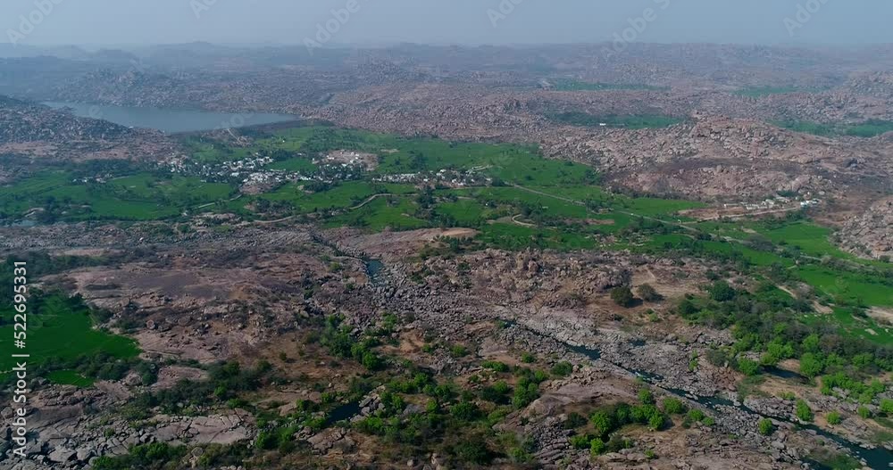 Aerial shot of rocky bouldery landscape and rice fields along river Aerial shot of rocky bouldery landscape and rice fields along river