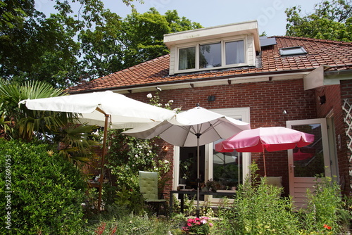 Three different umbrellas in a Dutch backyard on a sunny day. June, Netherlands.
