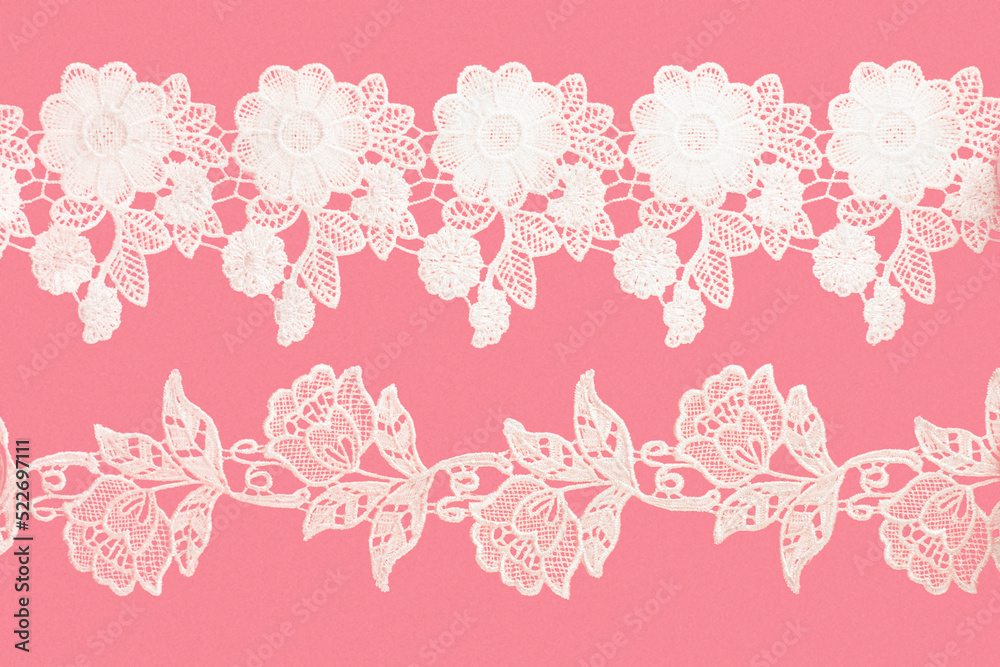 White laces with flowers and leaves on pink background isolated horizontally