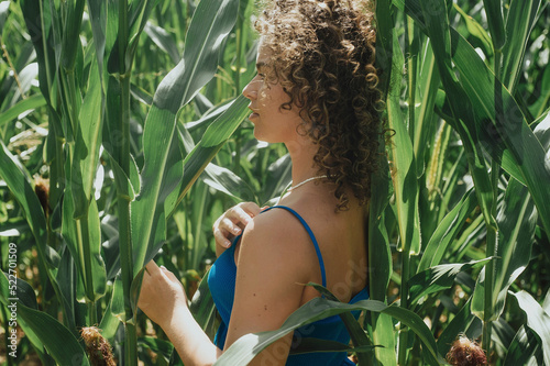 beautiful woman in stylish dress posing in a corn field on a sunny day