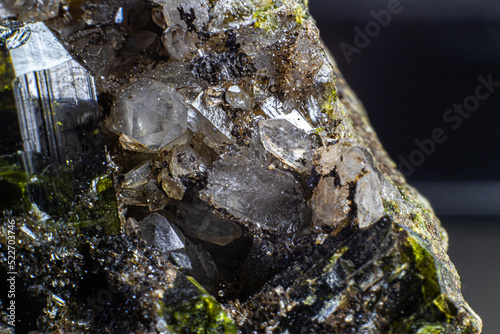 Ultra macro picture of small quartz points with one dark green epidote spike on matrix