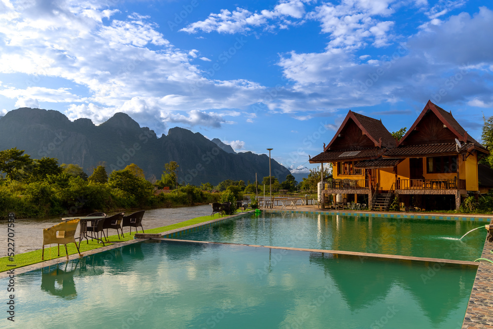 Naklejka premium Vang Vieng Laos a beautiful city on the river with huge rising mountains and slow flowing river.