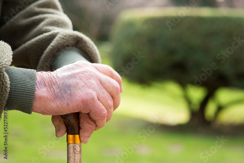 hands of ederly man holding a cane