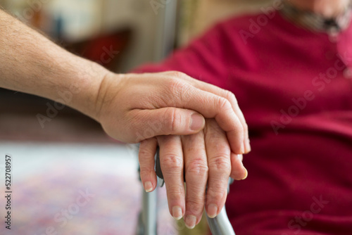 hands of ederly woman and young people holding a cane - mutual aid,