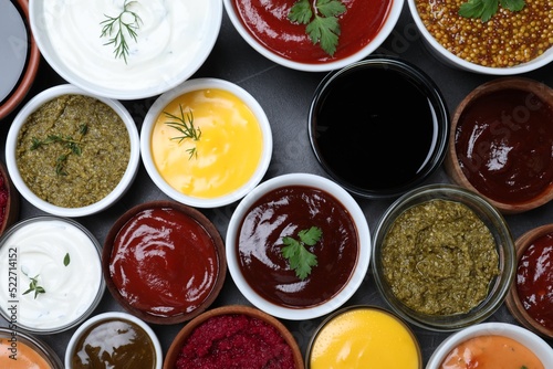 Wallpaper Mural Many different sauces and herbs on black table, flat lay Torontodigital.ca