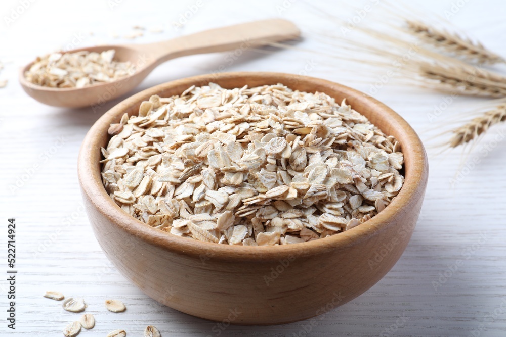 Oatmeal, bowl and spoon on white wooden table Oatmeal, bowl and spoon on white wooden table