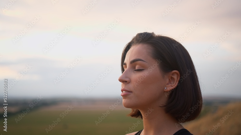 Calm woman enjoying free time for yoga practice and making breath exercises Calm woman enjoying free time for yoga practice and making breath exercises